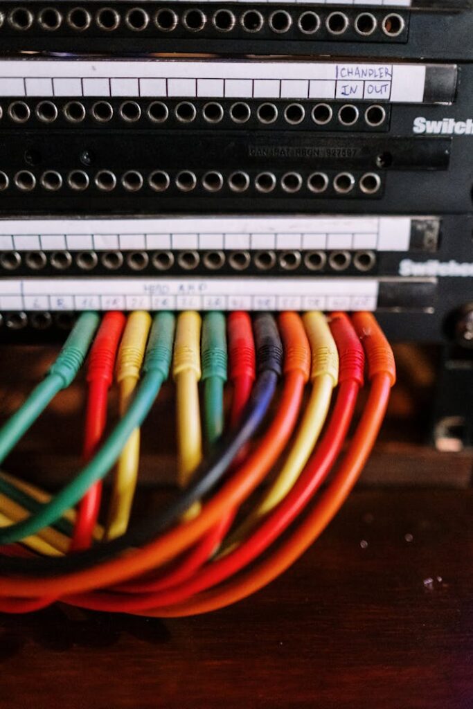 Vibrant cable wires connected to a patch panel in a professional audio setup.